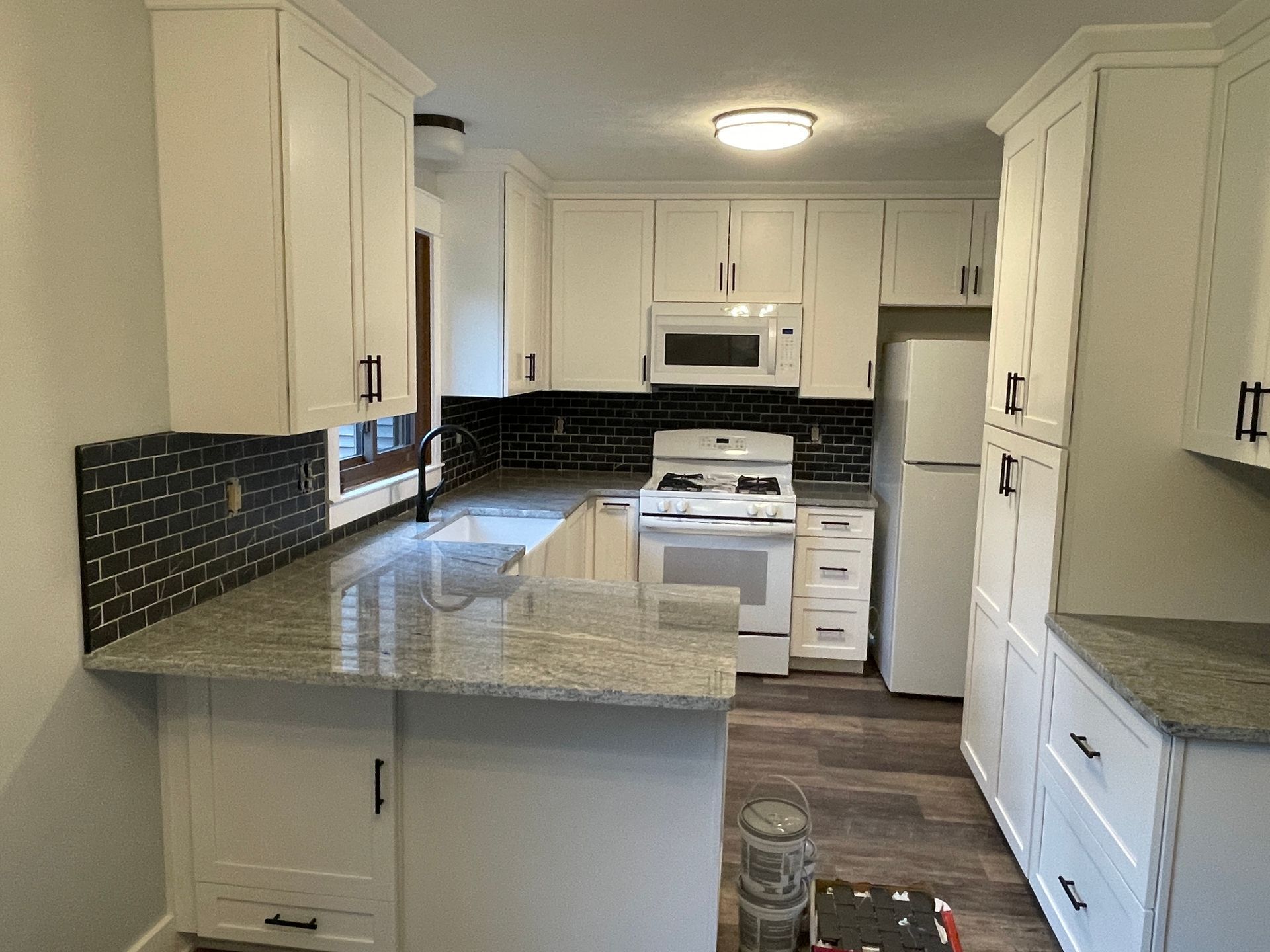 Ceiling with plastic sheeting for painting; blue tape, rectangular metal fixture with hole, kitchen visible.