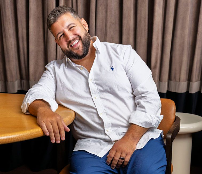 A specialist recruiter in a suit is smiling and holding a clipboard