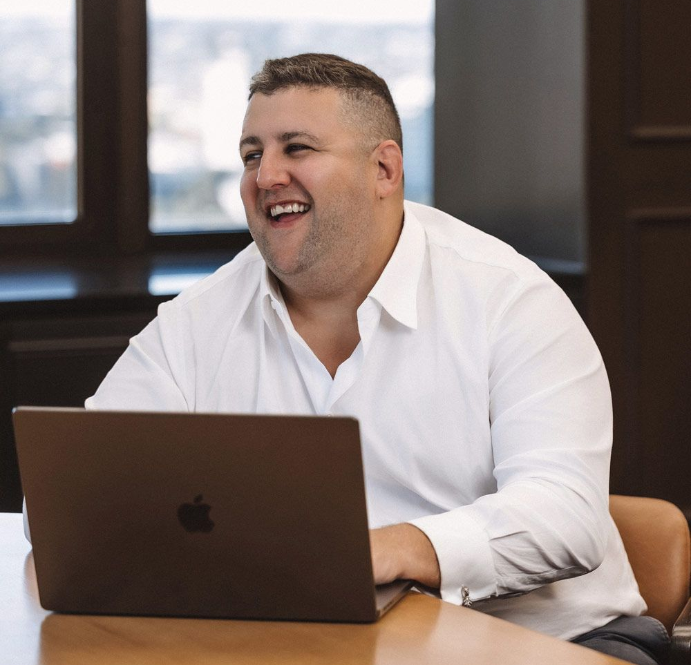 A specialist recruiter in a suit is smiling and holding a clipboard
