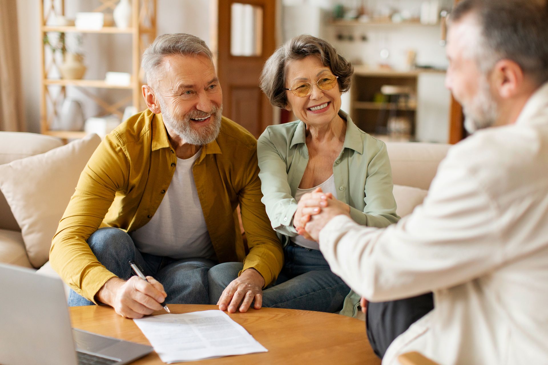 Real estate agent holding documents, gesturing toward modern home entrance.