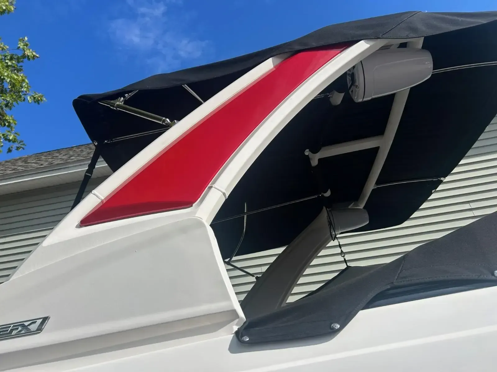 A white boat with a red and black stripe on the side