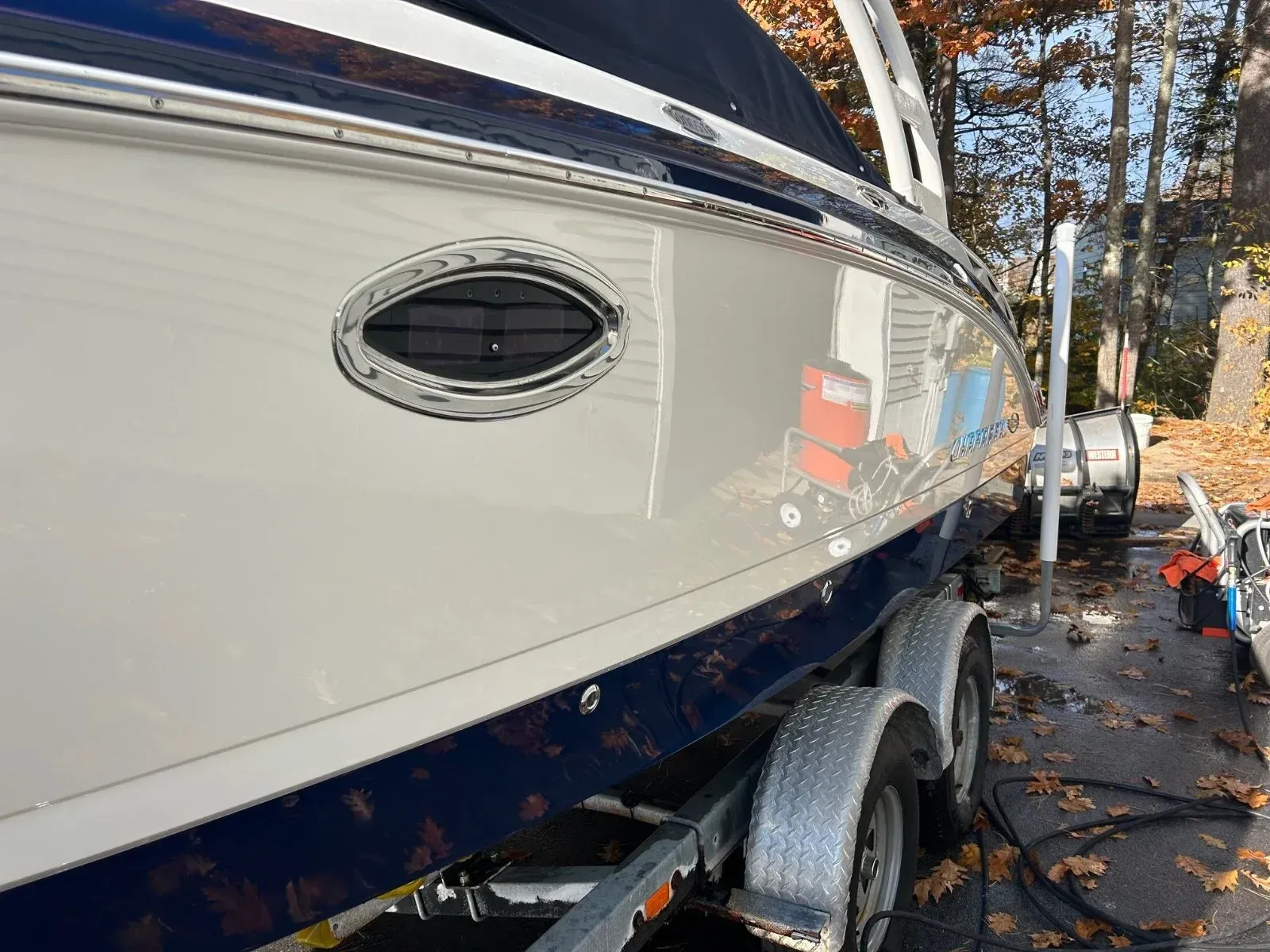 A boat is sitting on a trailer in a parking lot.