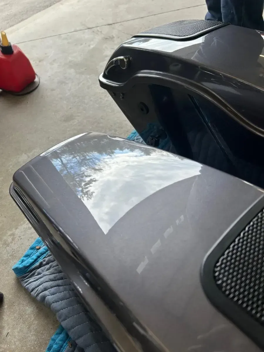Close-up of a gray motorcycle body panel with glossy reflections.