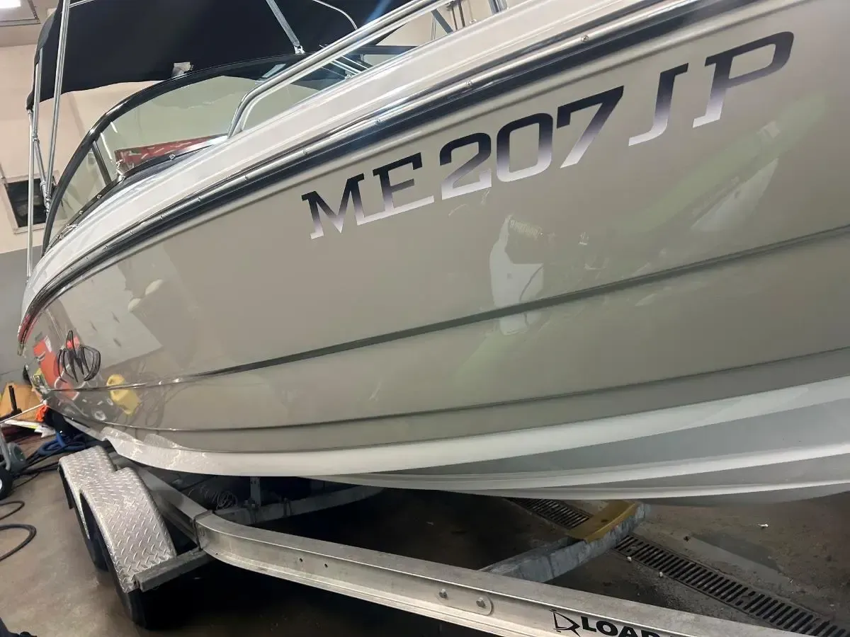 White boat on trailer at dock with registration number ME 2071P.