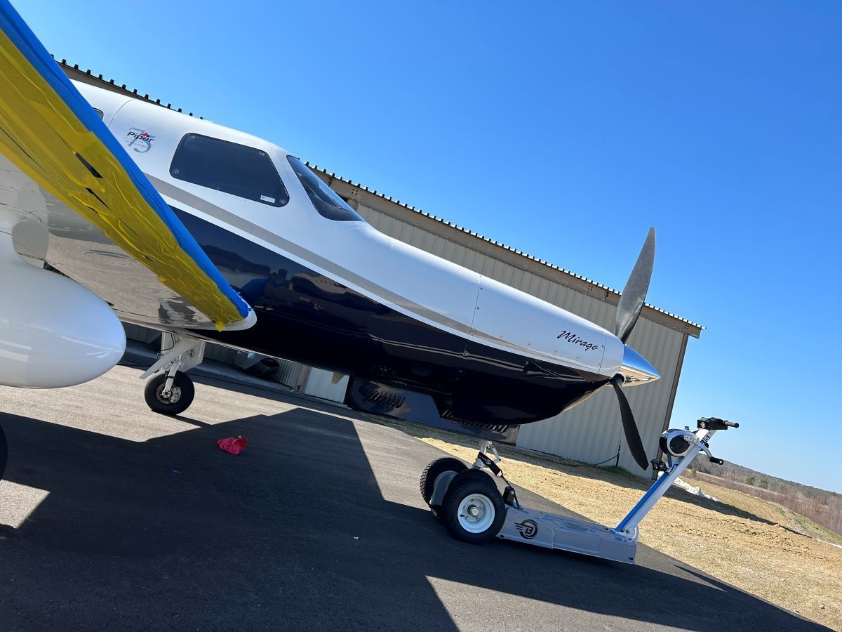 A small plane is being towed by a tow truck