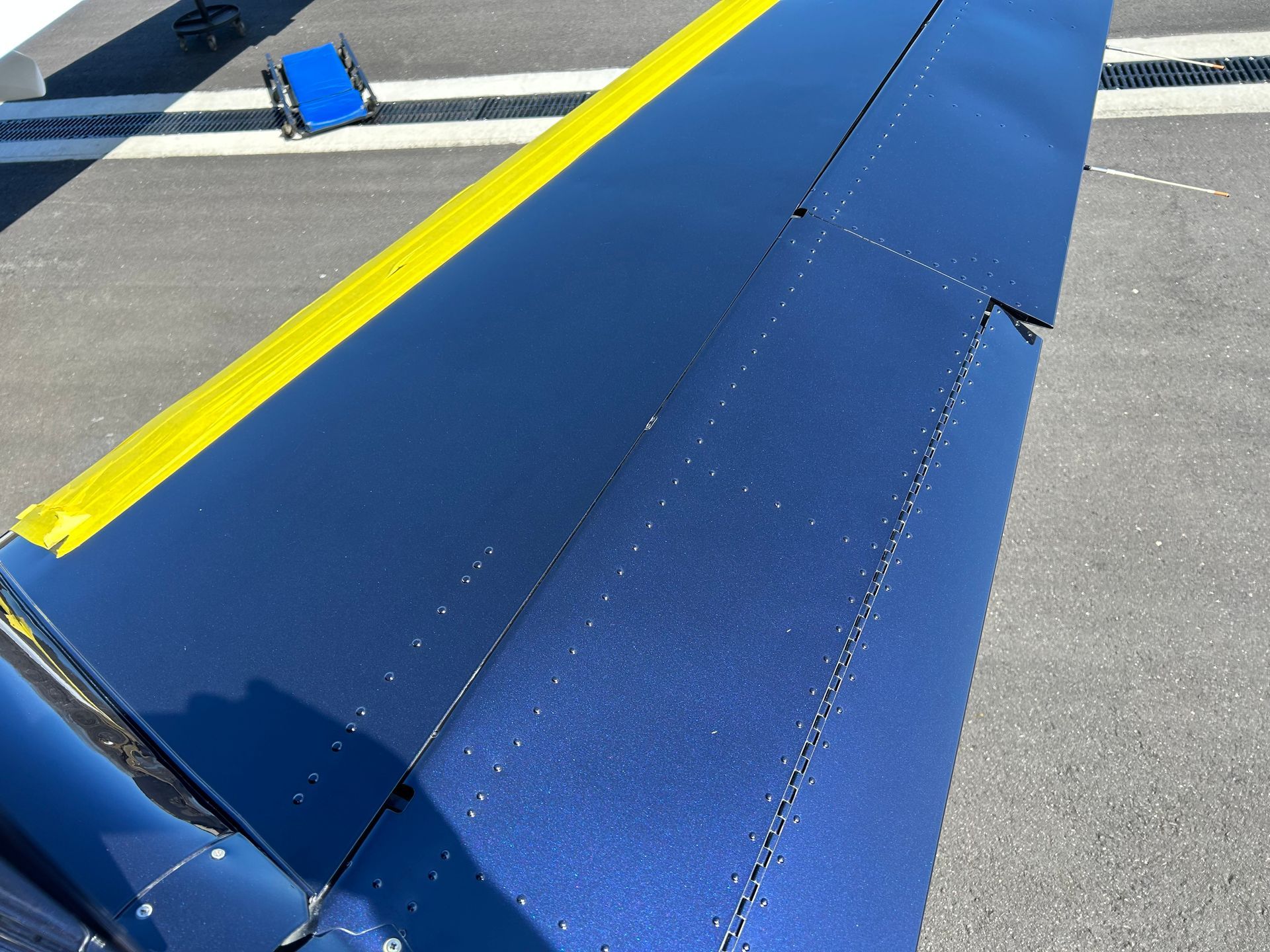 A close up of a blue and yellow airplane wing