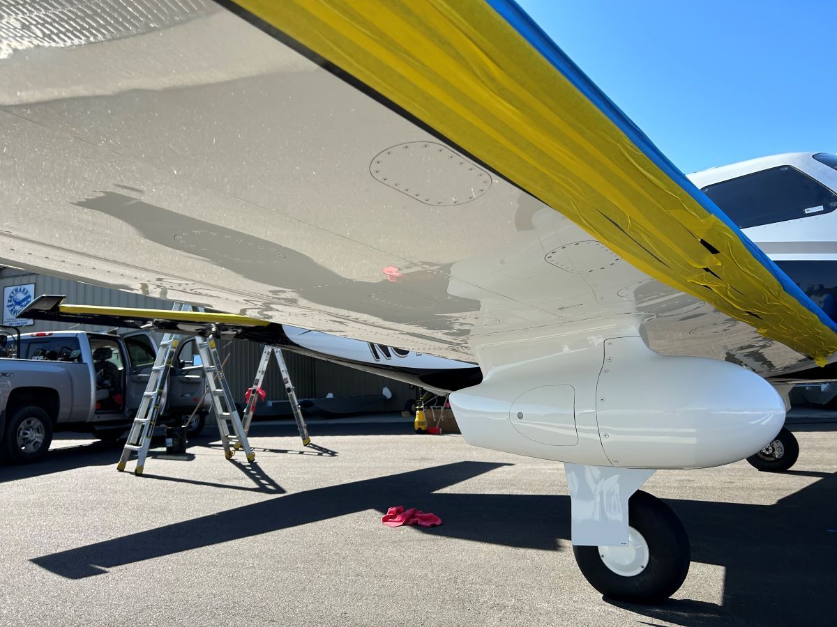 A yellow and blue airplane is parked in a parking lot