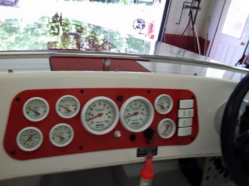 The dashboard of a boat has a lot of gauges on it