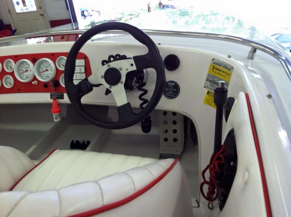 A boat with a steering wheel and a seat