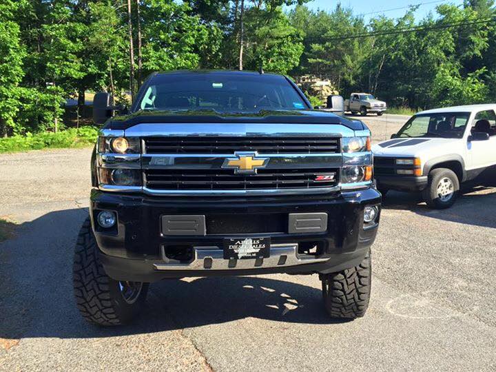 A black chevrolet truck is parked in a parking lot.