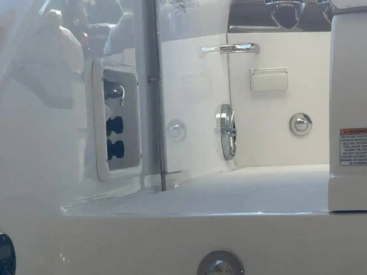 White boat interior with switches, handles, and a warning label.