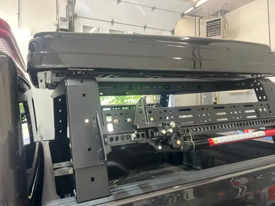 A roof rack is sitting on top of a truck in a garage.