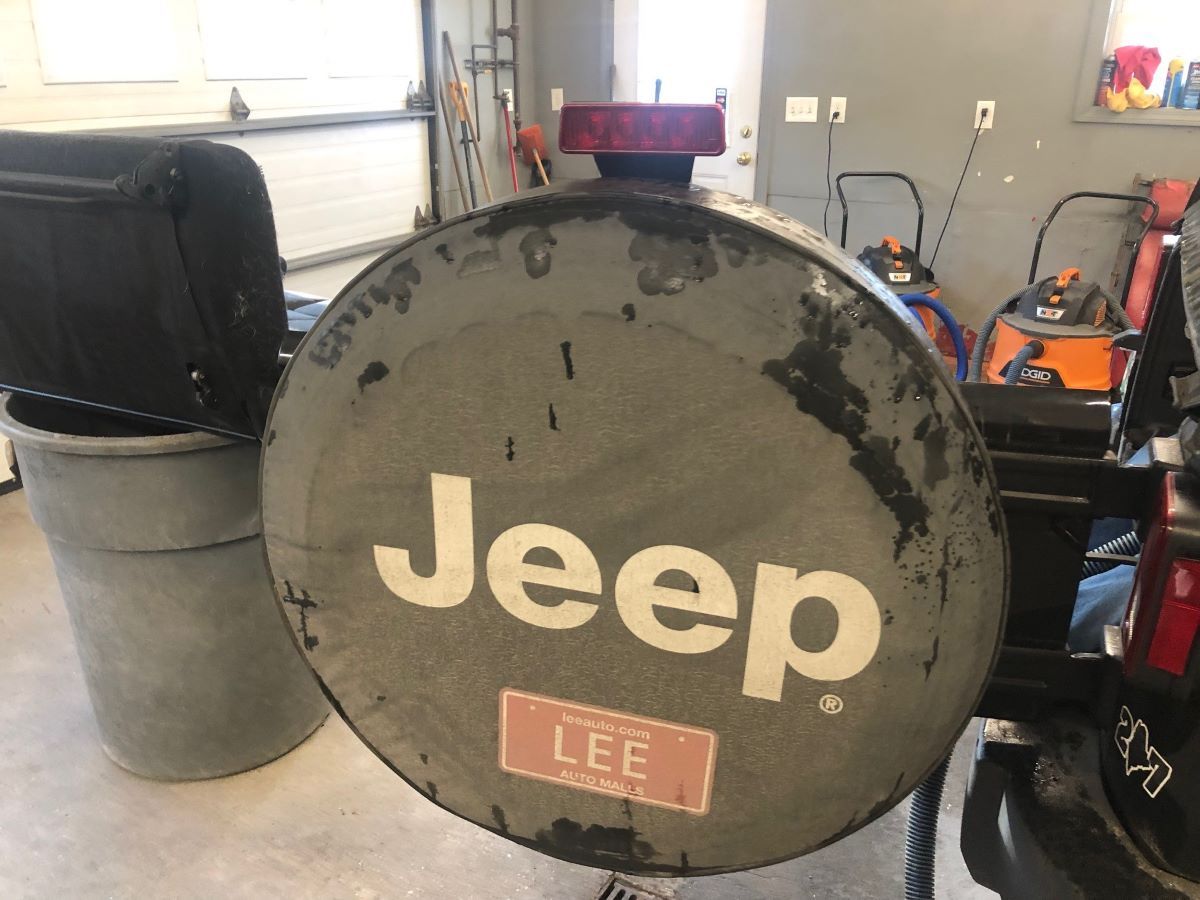 A tire cover for a jeep is sitting in a garage.