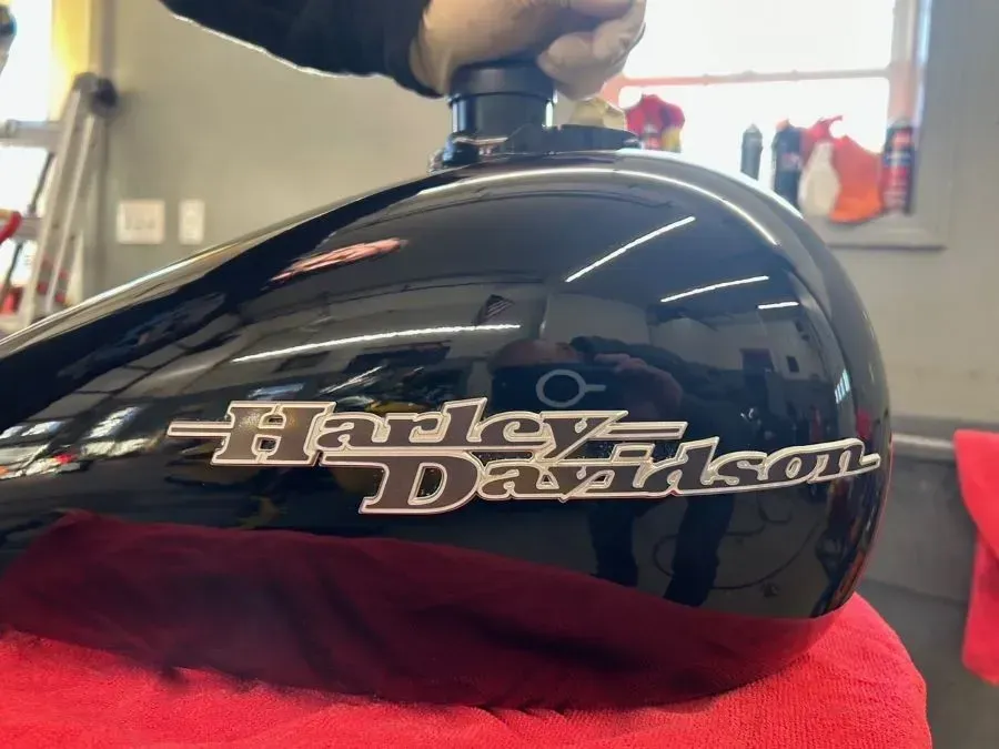 A black harley davidson motorcycle is sitting on a red towel