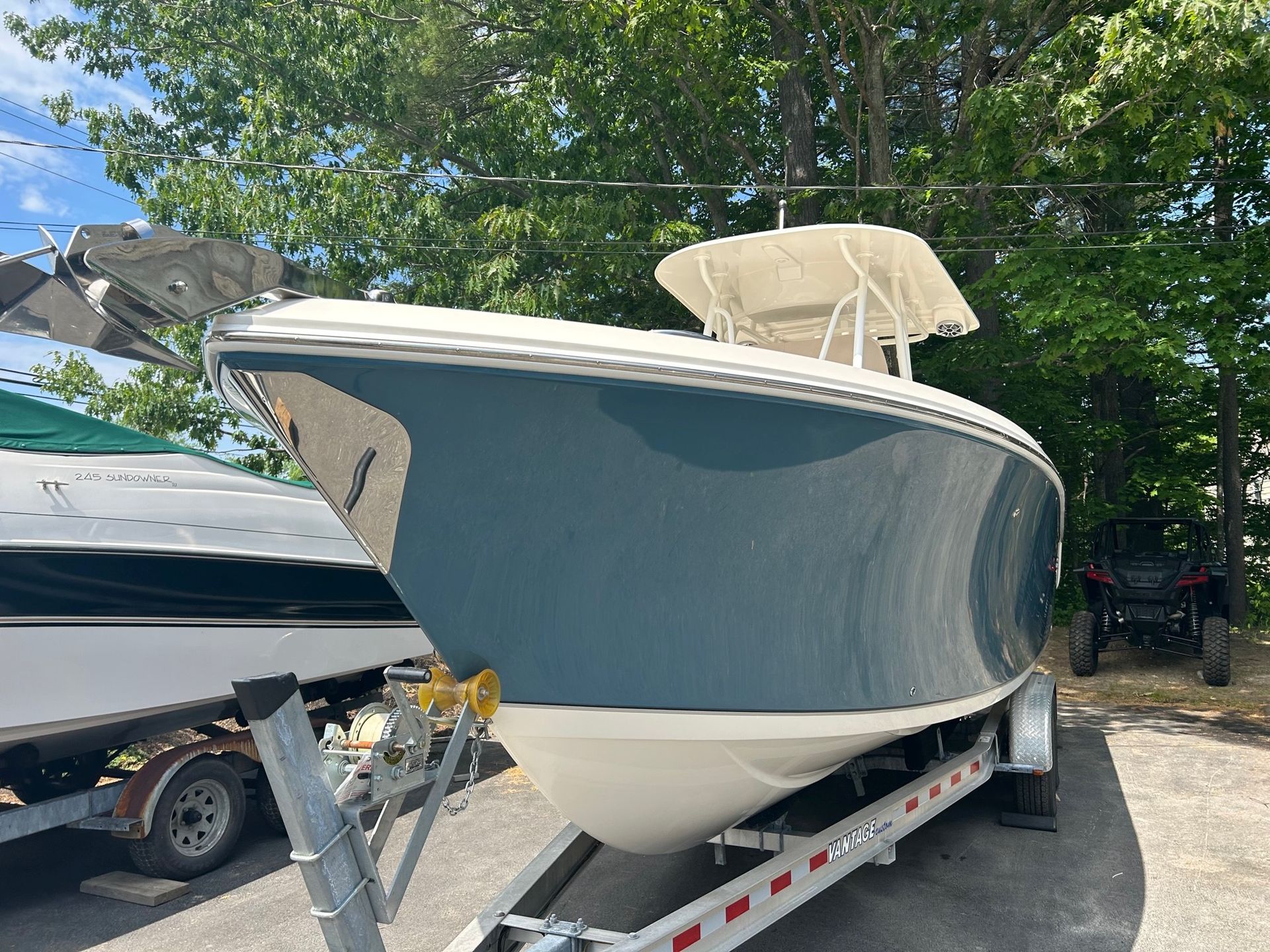A boat is parked on a trailer in a parking lot.