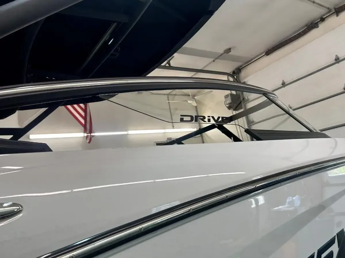 White car with black spoiler and rear window inside a garage or workshop
