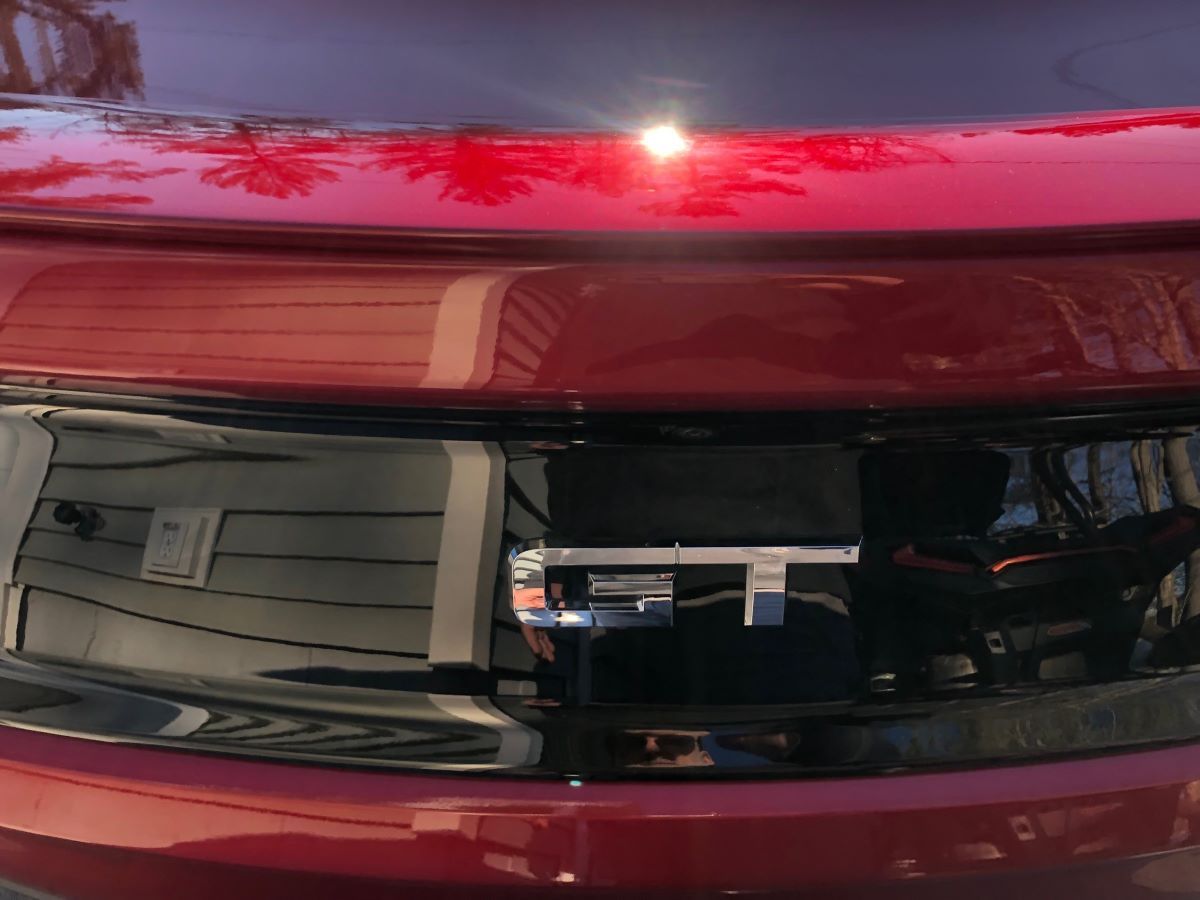 A close up of a red car with a black grille