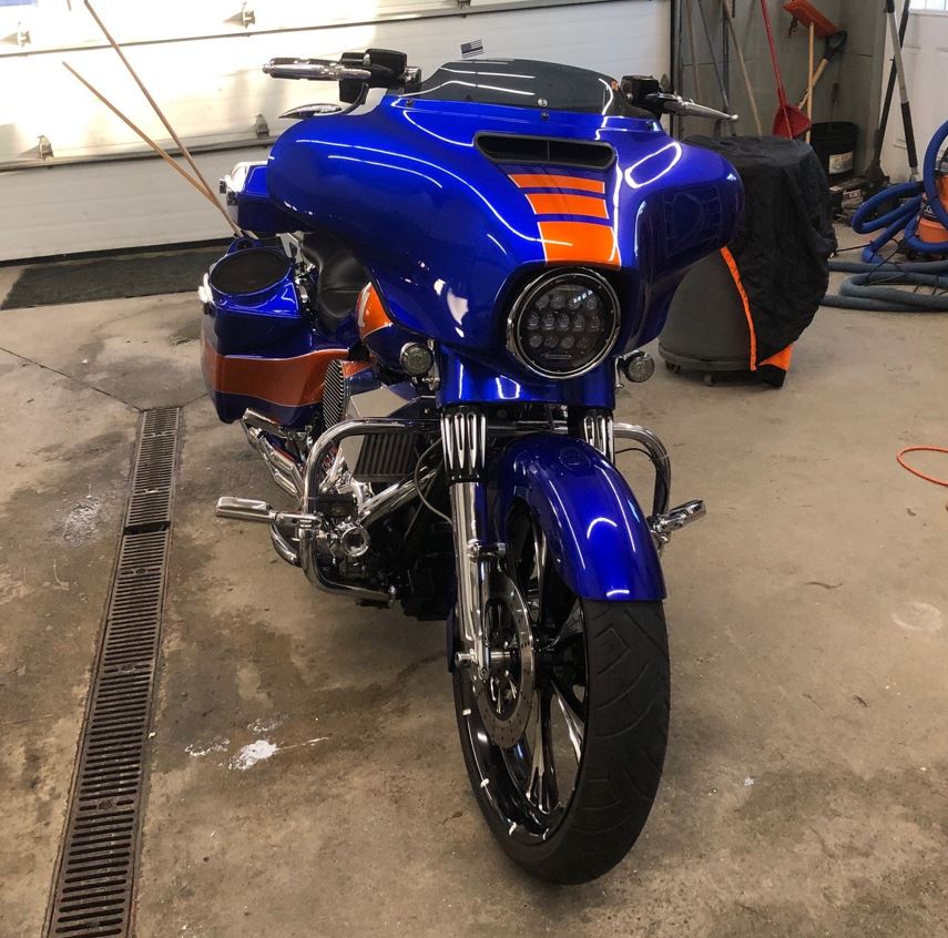 A blue and orange motorcycle is parked in a garage