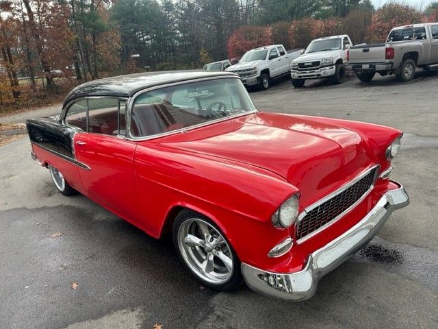 A red and black car is parked in a parking lot