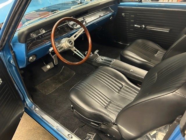 A blue car with black seats and a wooden steering wheel