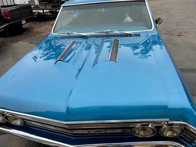 A blue car is parked in a parking lot