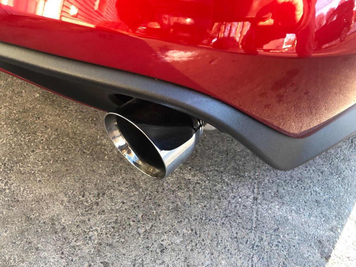 A close up of a red car 's exhaust pipe