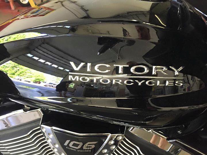 A black victory motorcycle is parked in a garage