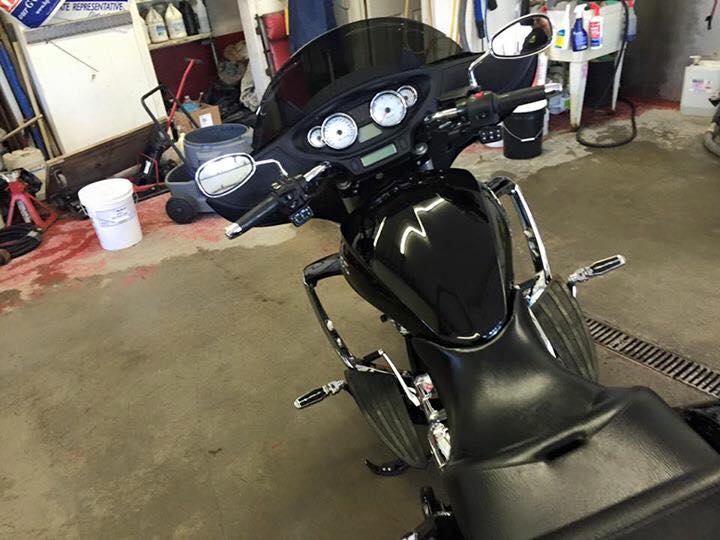 A black motorcycle is parked in a garage.