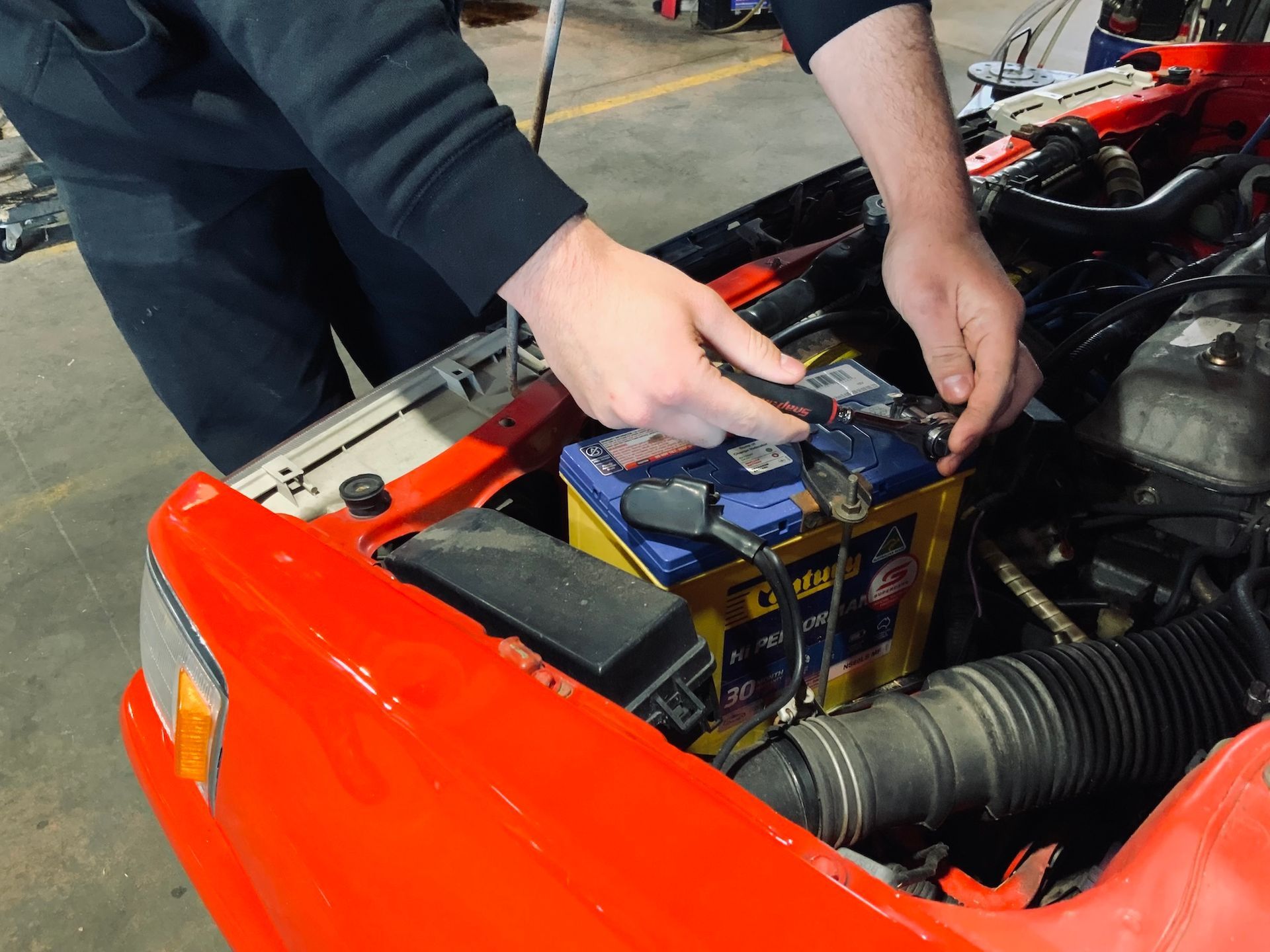 Mechanic Checking Car Battery — H.M. Mechanical in Westbrook, QLD