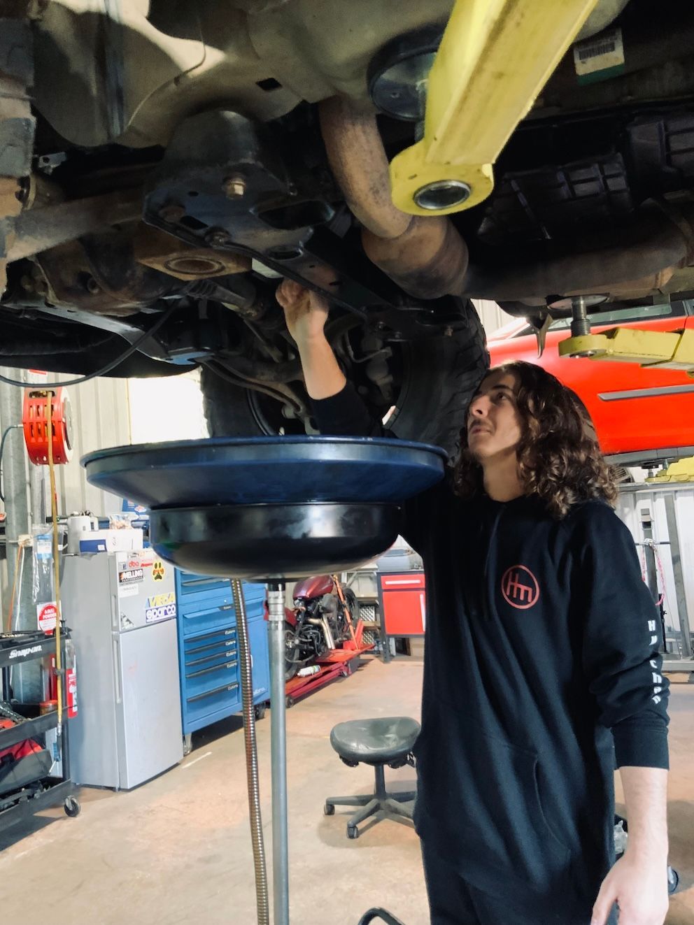 Mechanic Draining Oil — H.M. Mechanical in Drayton, QLD