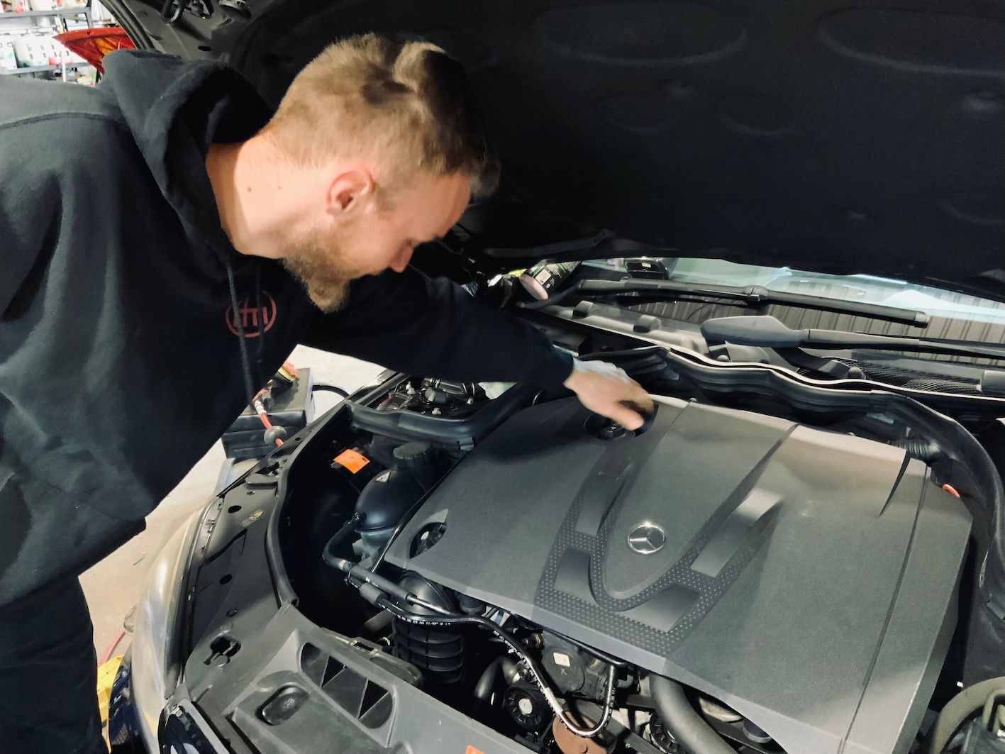Mechanic Checking Under Hood — H.M. Mechanical in Withcott, QLD