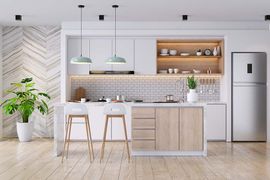 Modern kitchen with white cabinets, light wood island, two stools, stainless steel fridge, and a potted plant.