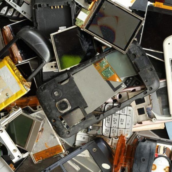 A pile of broken cell phones including a nokia phone