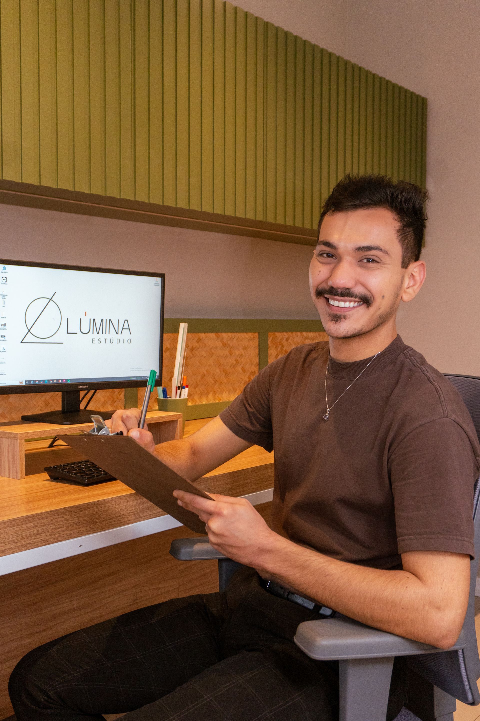 Consultor especializado em películas arquitetônicas, sentado à mesa com smartphone em ambiente iluminado por luz natural filtrada por vidro.
