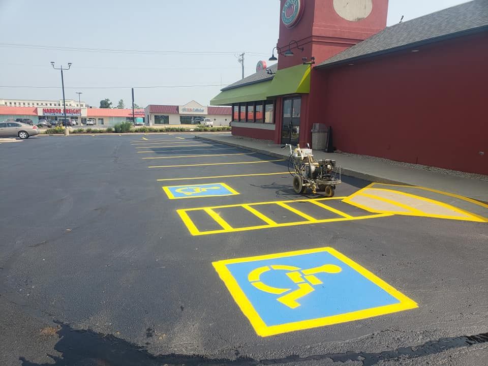 A handicapped parking spot is being painted in a parking lot