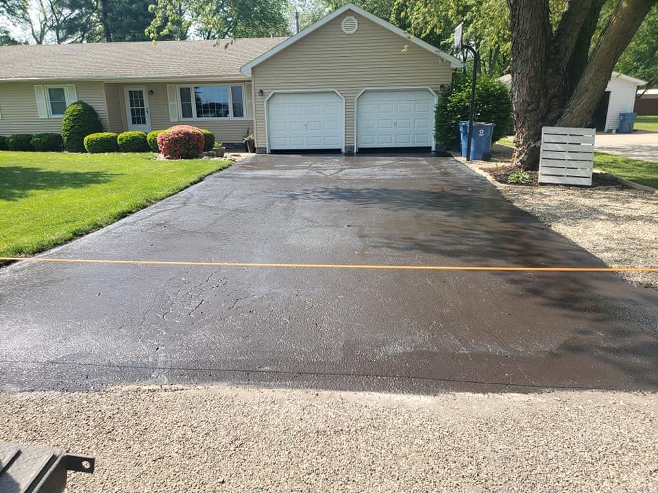 A driveway leading to a house with two garage doors.