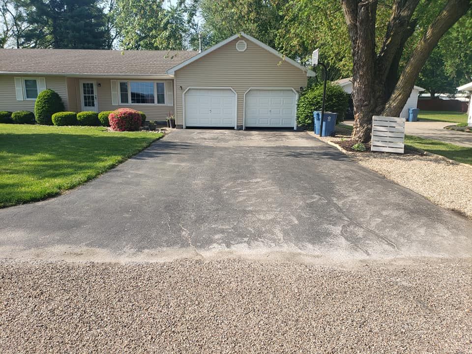 A driveway leading to a house with two garage doors