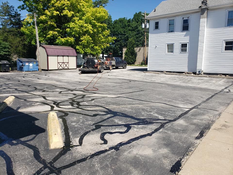 A parking lot with a white house in the background