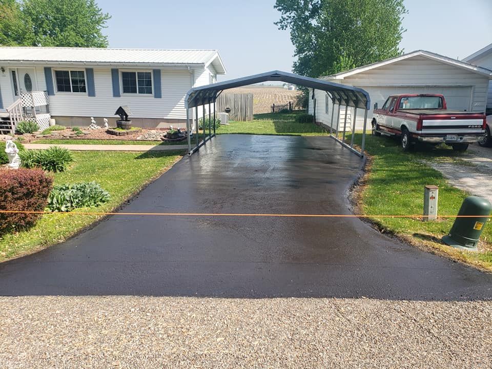 A driveway with a carport and a truck parked in front of a mobile home.