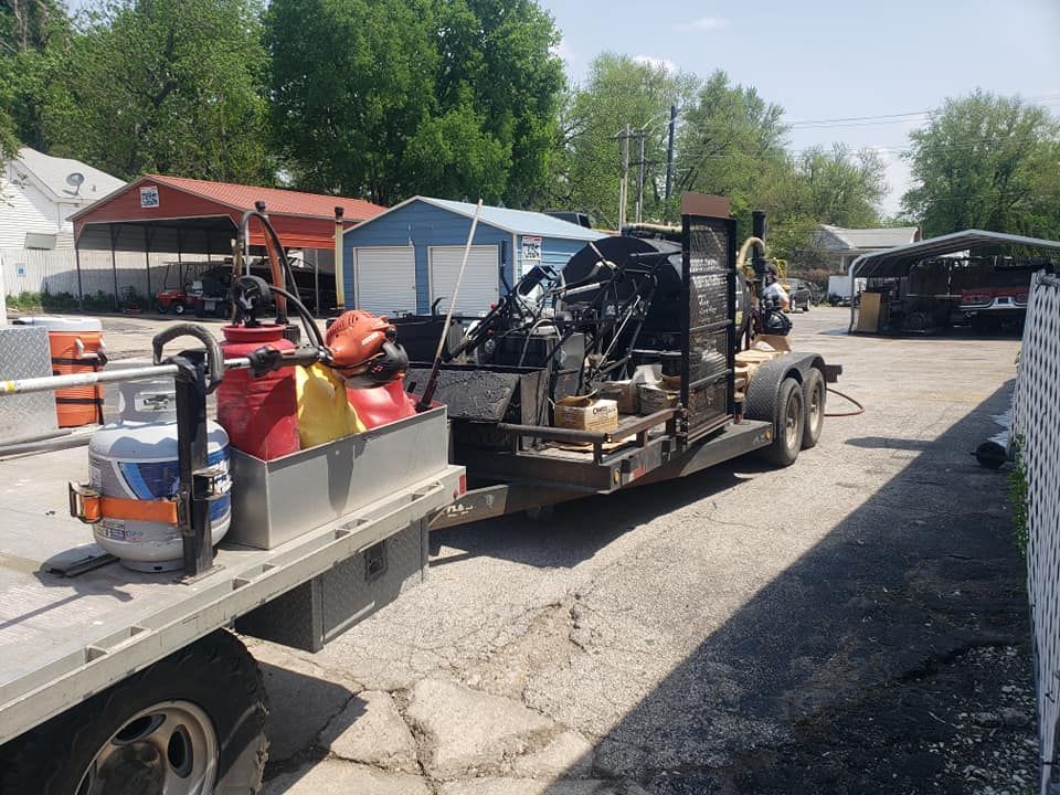 A truck is towing a trailer with a lot of equipment on it.