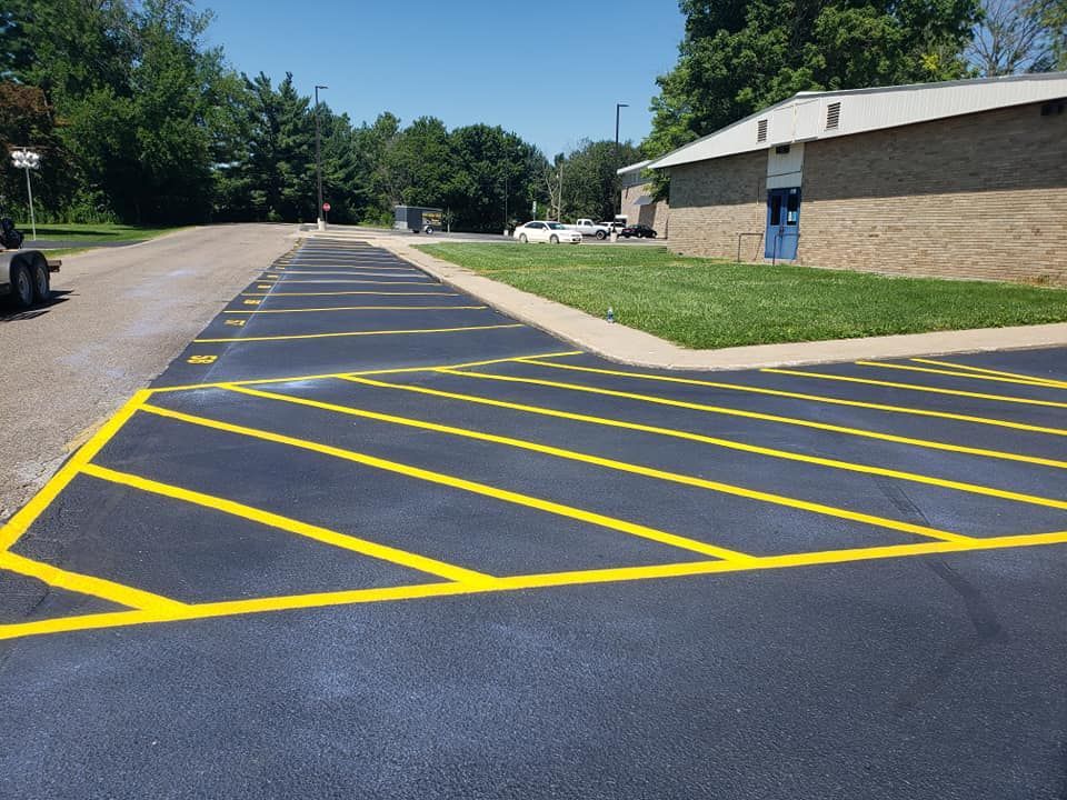 A parking lot with yellow lines on it in front of a building.