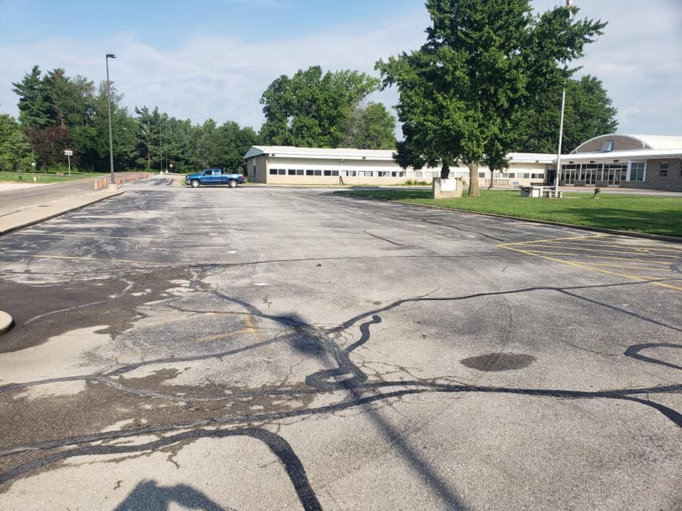 An empty parking lot with a building in the background