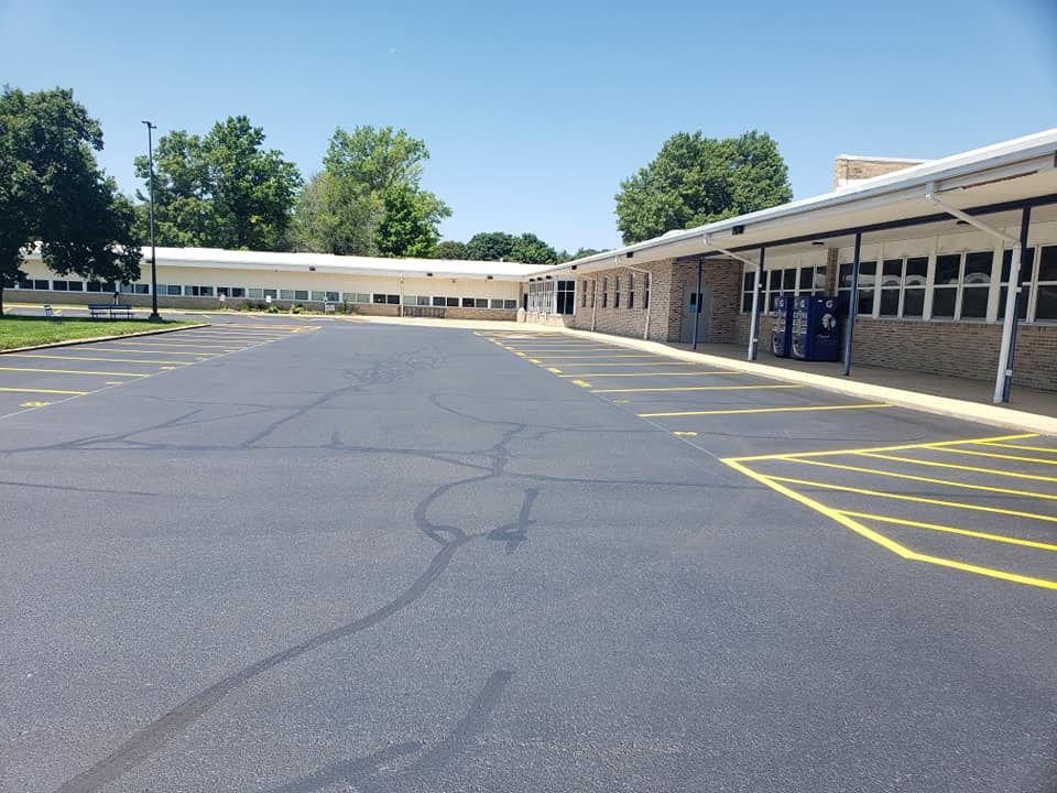 An empty parking lot in front of a school building