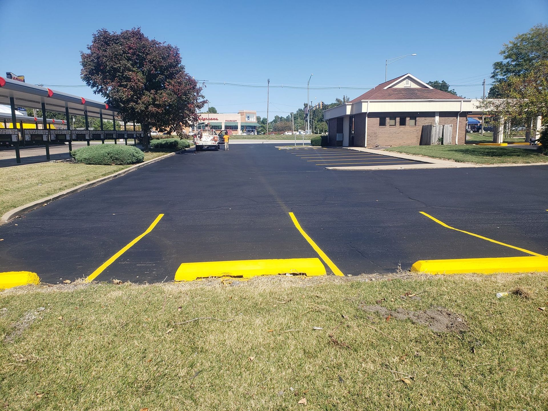 A parking lot with yellow curbs and a building in the background