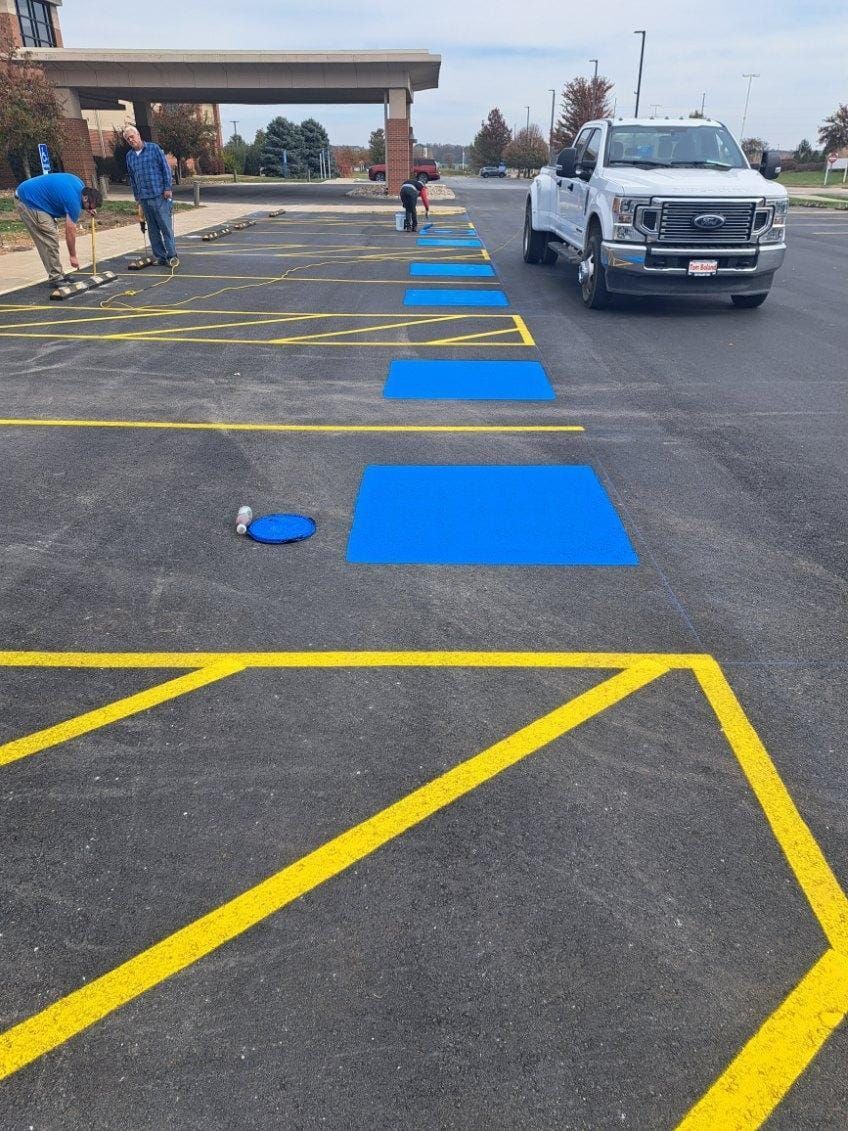 A white truck is driving down a parking lot with blue squares painted on it