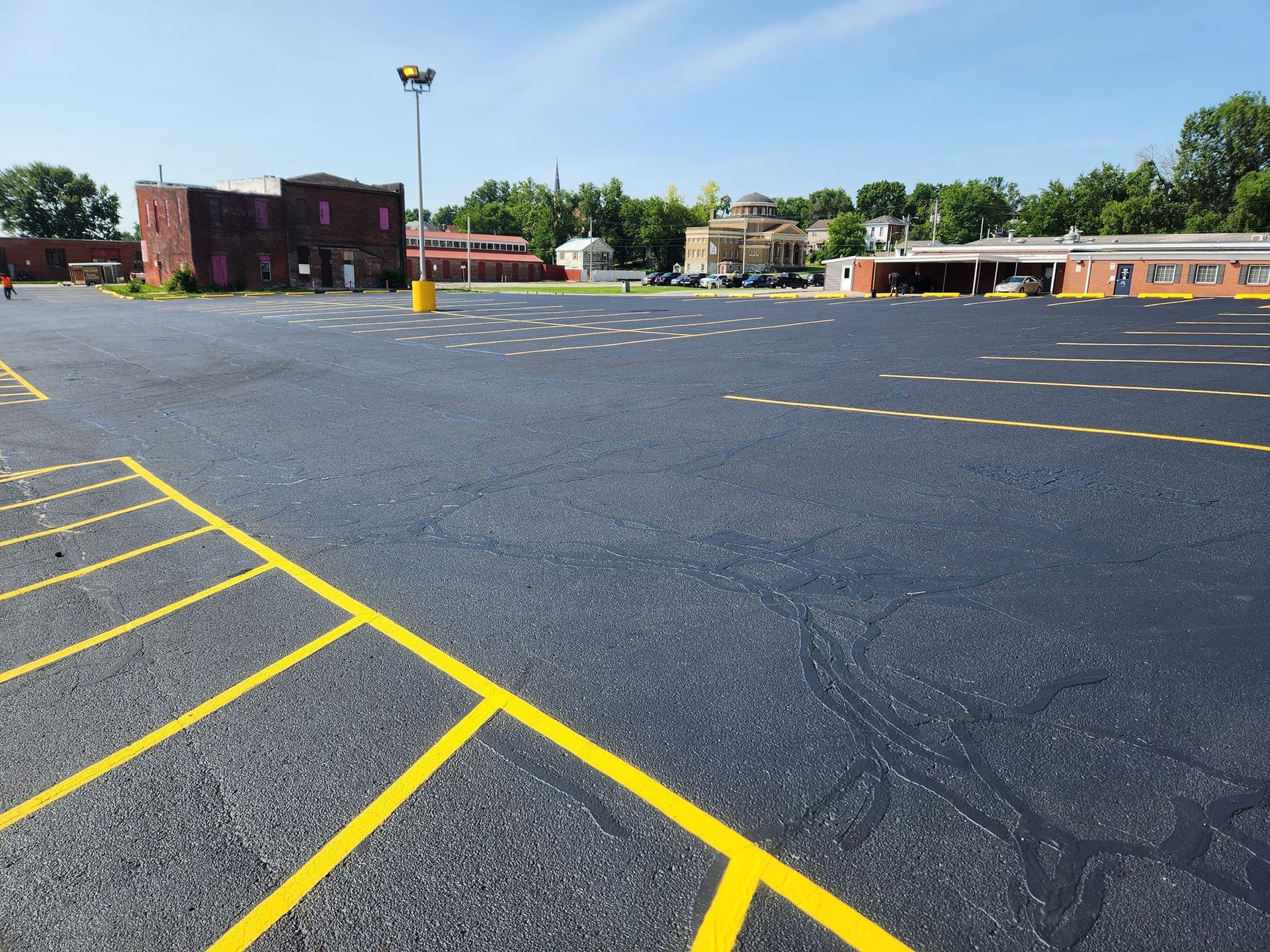 A parking lot with yellow lines and a building in the background
