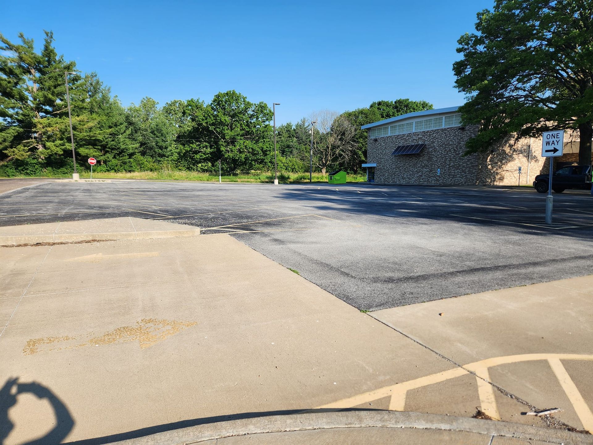 A shadow of a person taking a picture of a parking lot