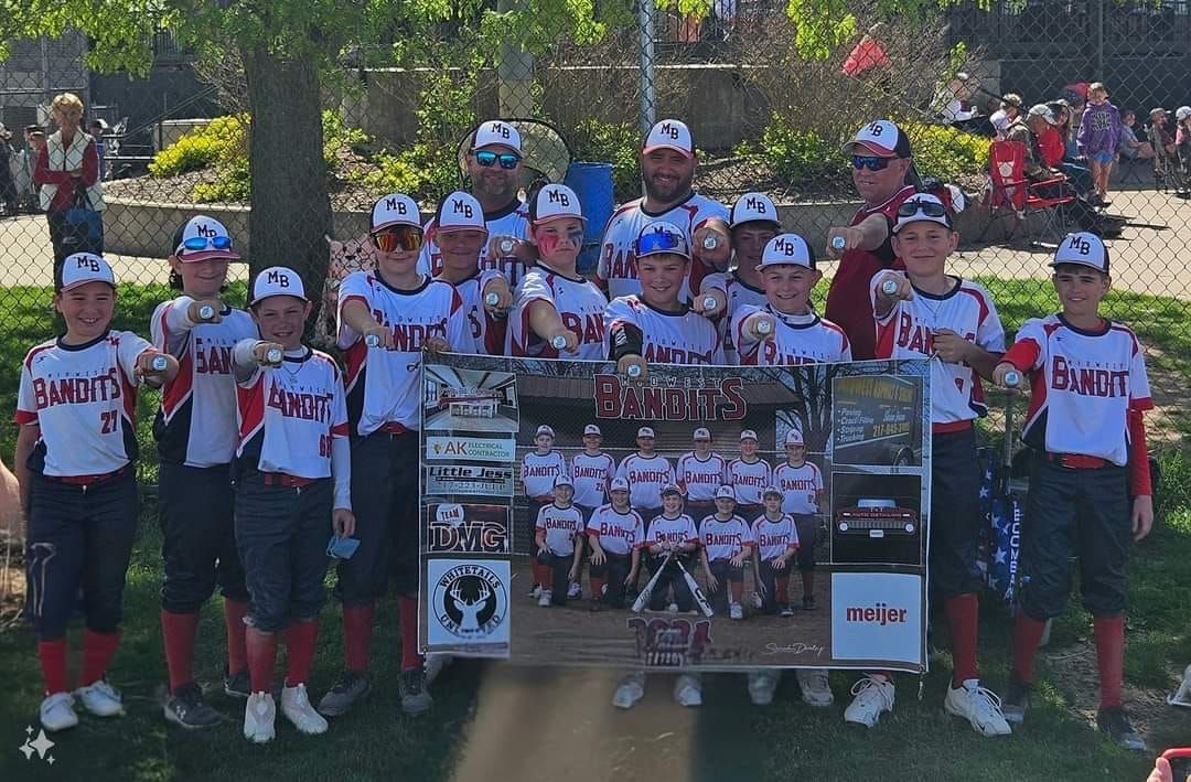 A group of young boys are posing for a picture in a park.
