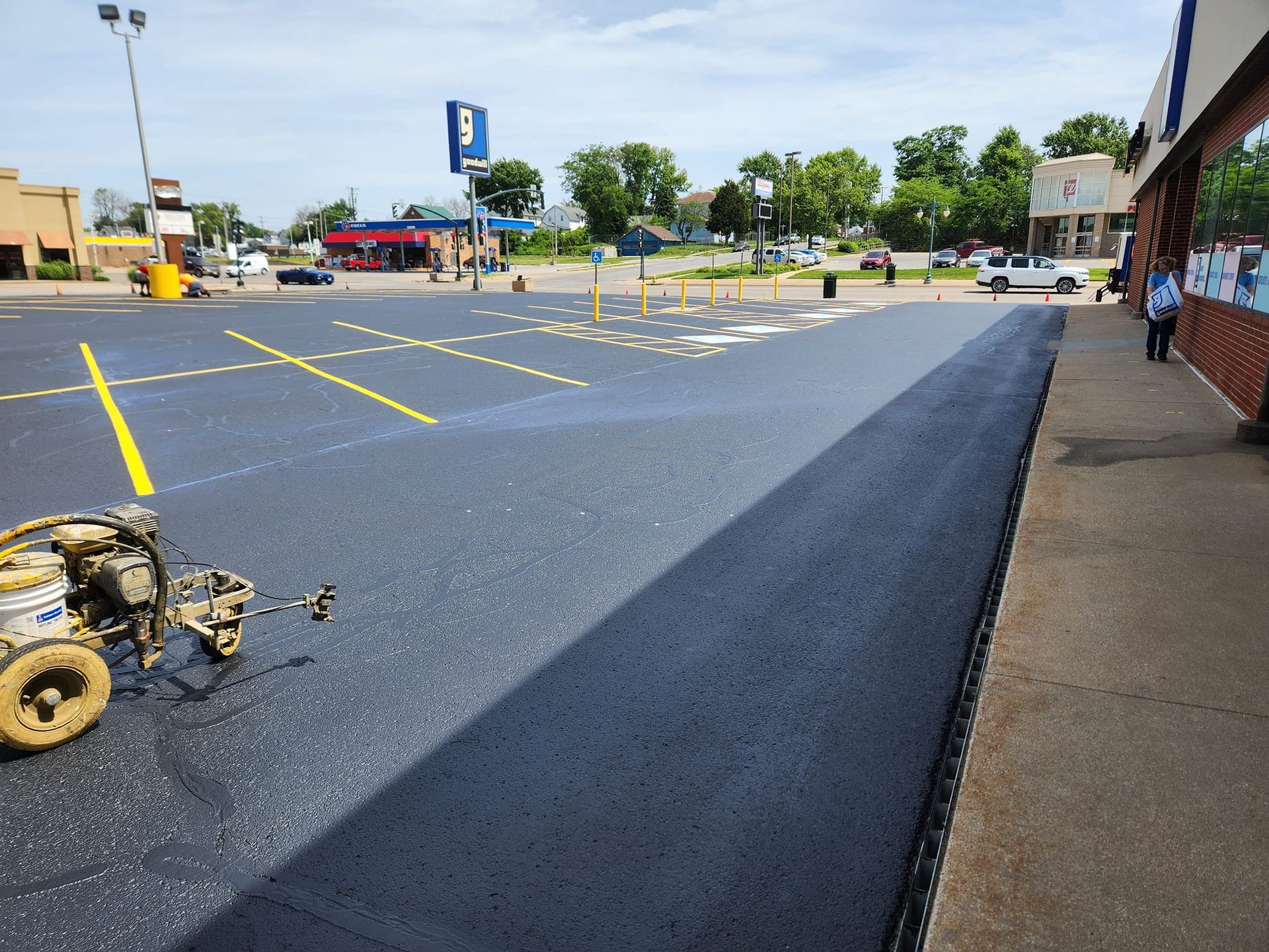 A person is walking down a sidewalk next to a parking lot