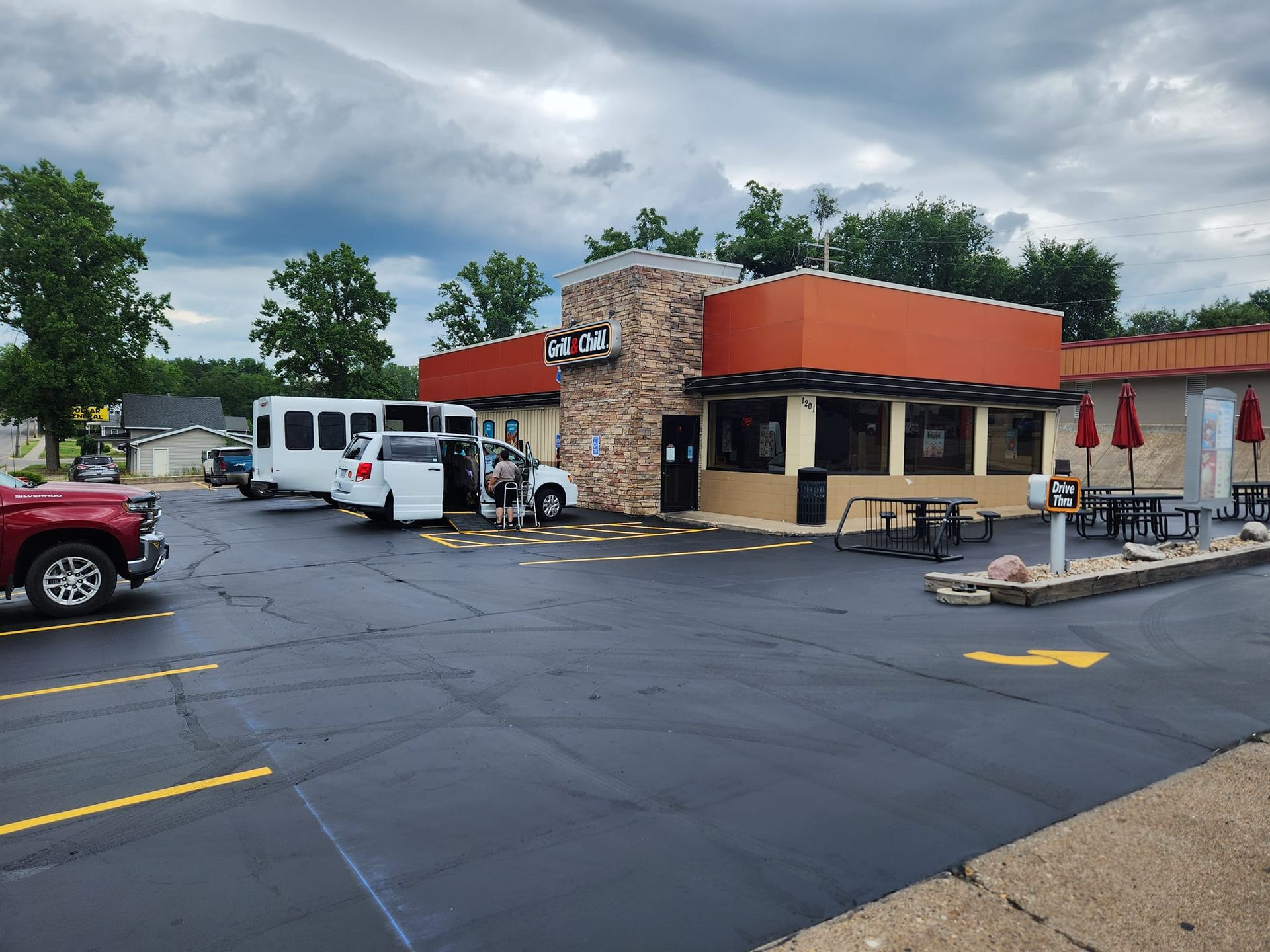 A restaurant with a lot of cars parked in front of it.
